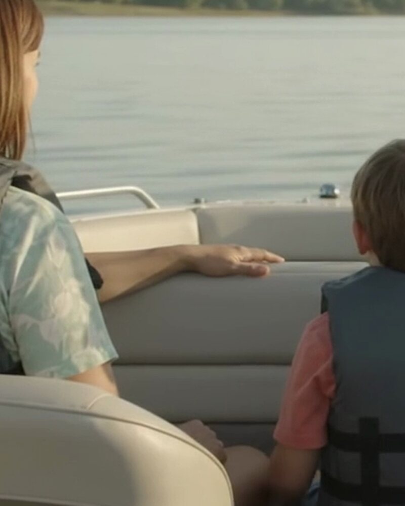 A family wearing life jackets aboard a recreational boat on calm water